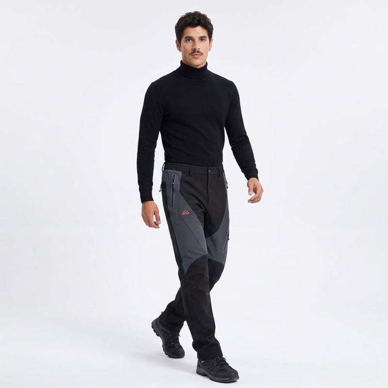 Black insulated softshell winter pants worn by a model walking, full-length front view — AI-generated studio image